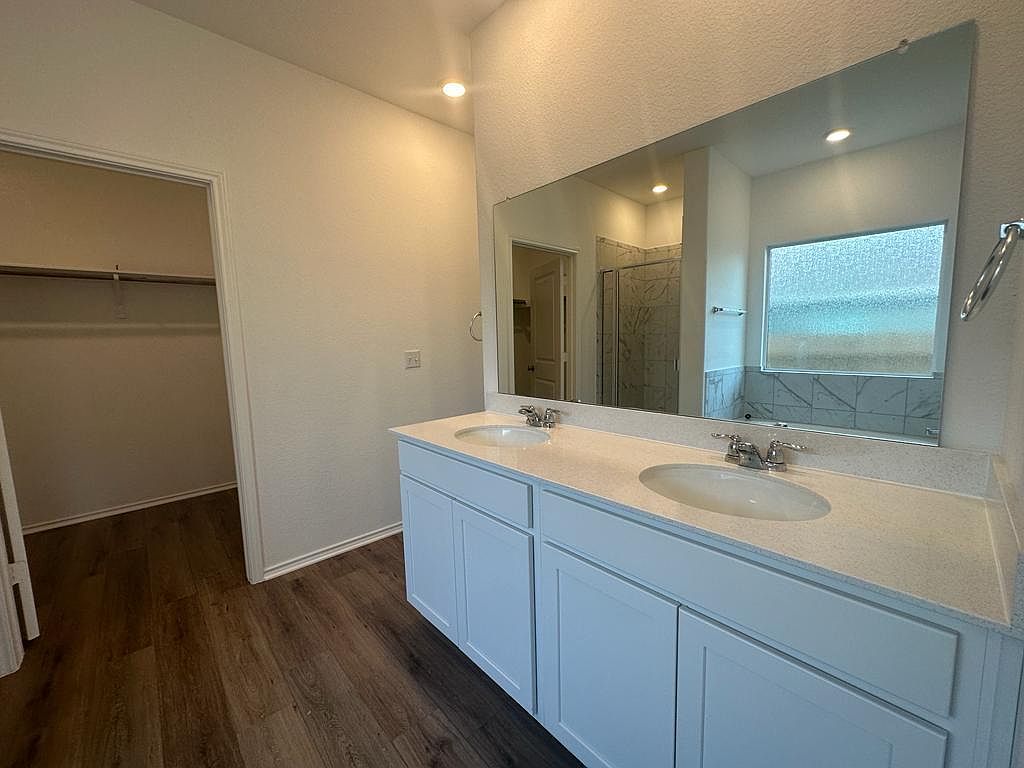 160 River Rise Road Kyle, TX 78640 - Photo 21 of 35 Double vanity with white cabinetry, light-toned countertop, and dual undermount sinks