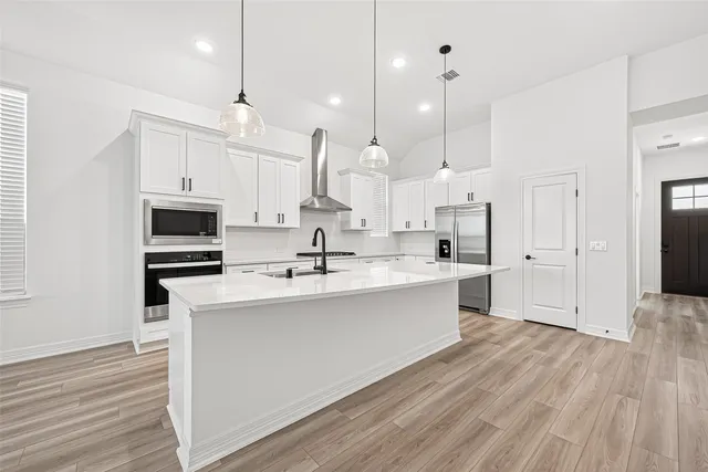 a large kitchen with stainless steel appliances kitchen island a large counter space a sink and a refrigerator