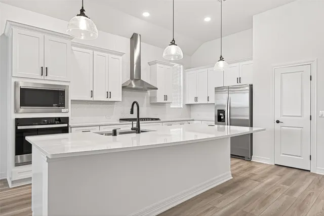 a open kitchen with stainless steel appliances granite countertop a sink a stove and a refrigerator