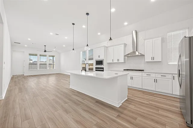 a large kitchen with kitchen island a sink stainless steel appliances and cabinets