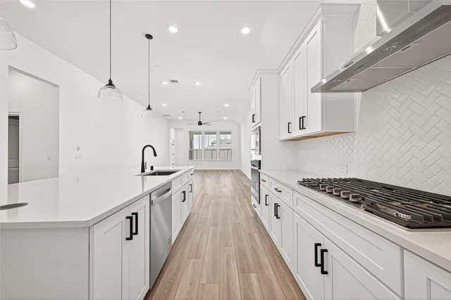 a kitchen with white cabinets and appliances
