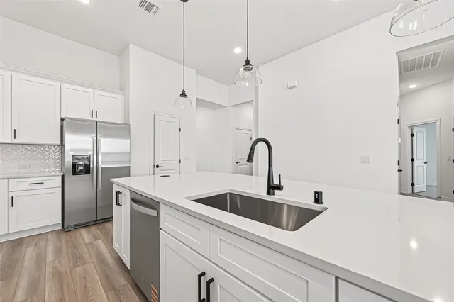 a kitchen with stainless steel appliances a sink a counter space and refrigerator