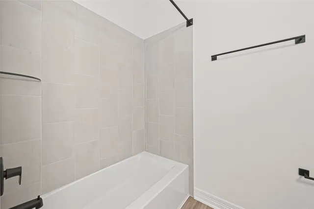 a bathroom with a white bath tub and a shower