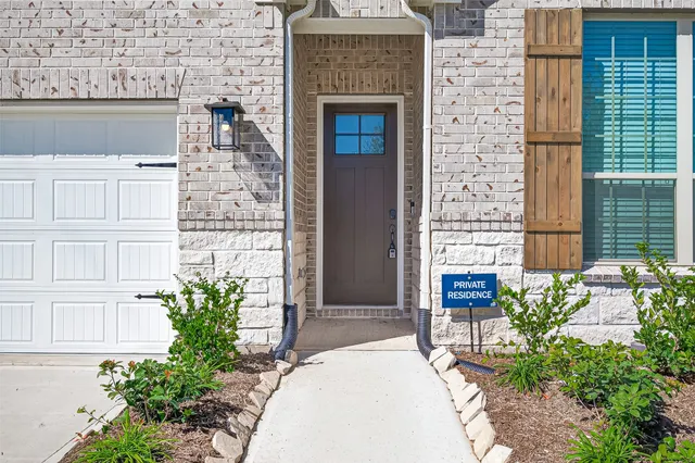 a stone building with potted plants in front of door