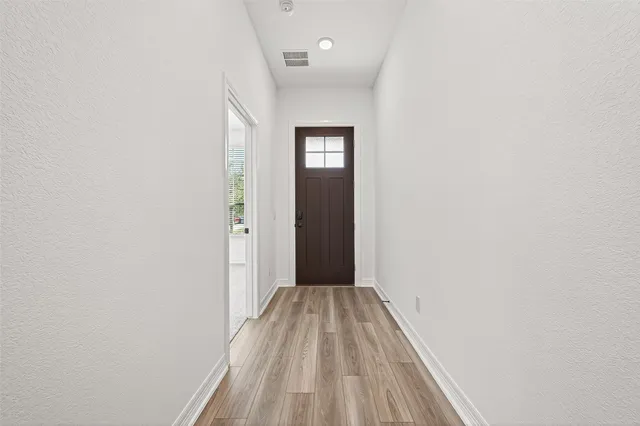 a view of a hallway with wooden floor