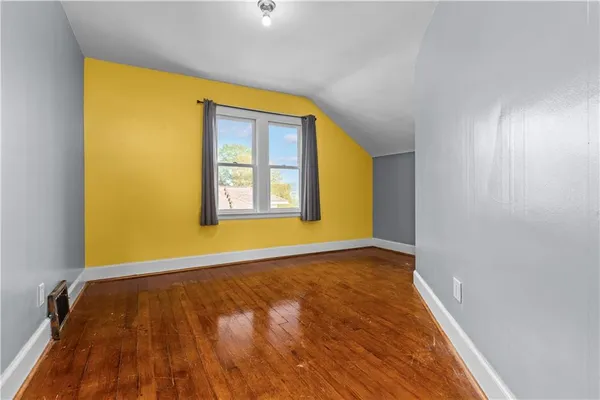 a view of a hallway with wooden floor and a cabinet