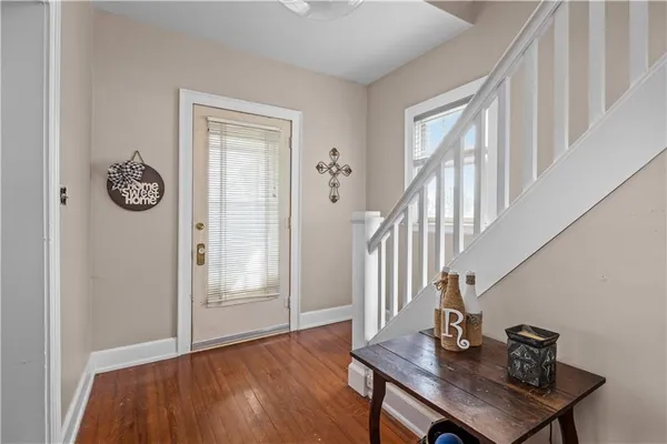 a view of a hallway with wooden floor and staircase