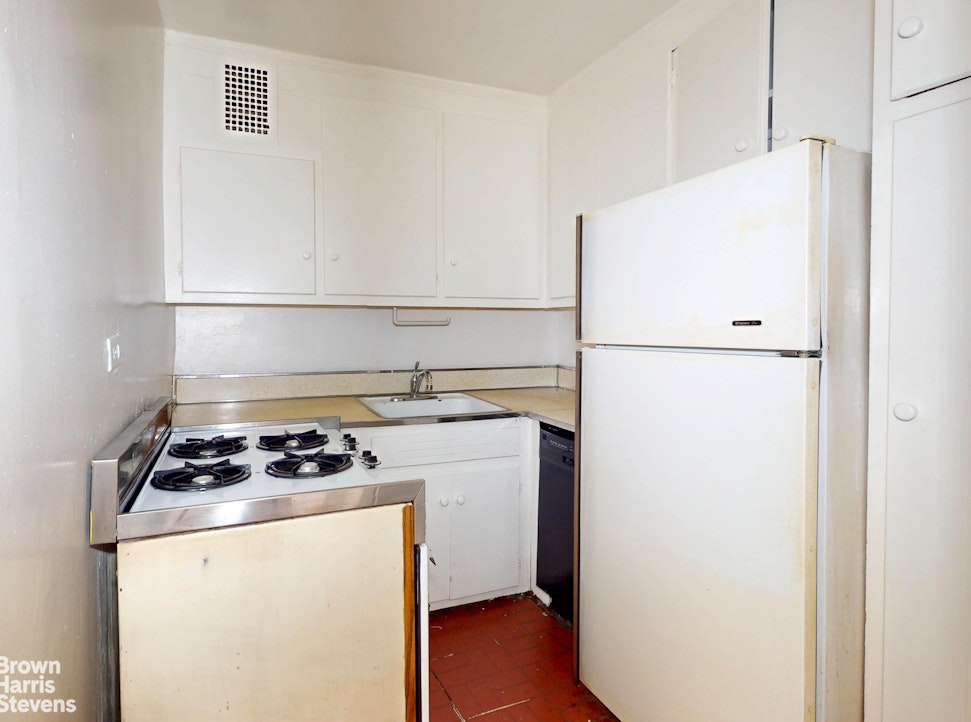 301 East 62nd Street, Unit 14B Manhattan, NY 10065 - Photo 7 of 14 a white refrigerator freezer and a stove sitting inside of a kitchen