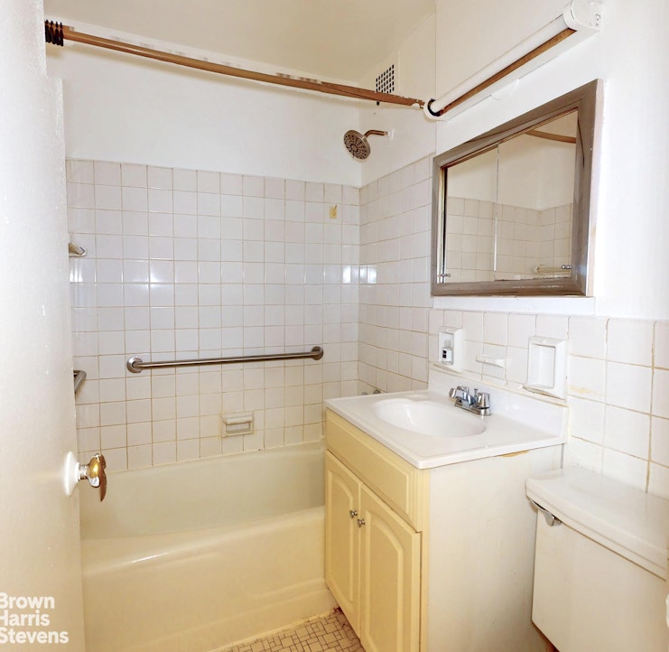 301 East 62nd Street, Unit 14B Manhattan, NY 10065 - Photo 9 of 14 a bathroom with a sink a mirror and a bathtub