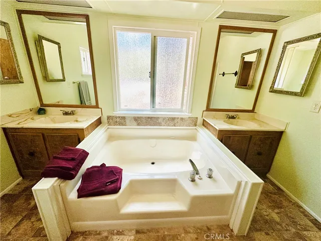 a bathroom with a tub sink and mirror