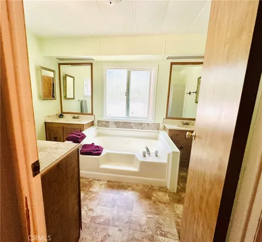 a bathroom with a tub sink and mirror
