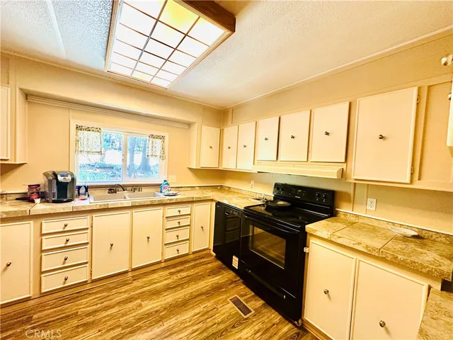 a kitchen with granite countertop a stove a sink and a refrigerator