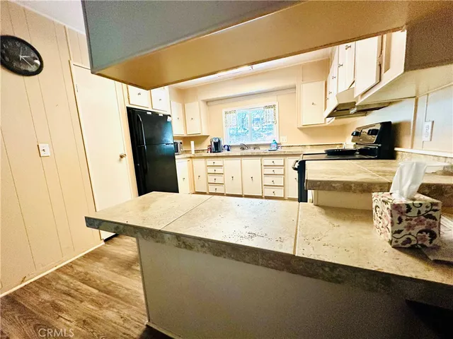 a kitchen with granite countertop a sink a stove and refrigerator