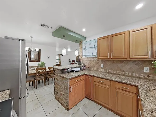 a kitchen with granite countertop a sink stove and cabinets