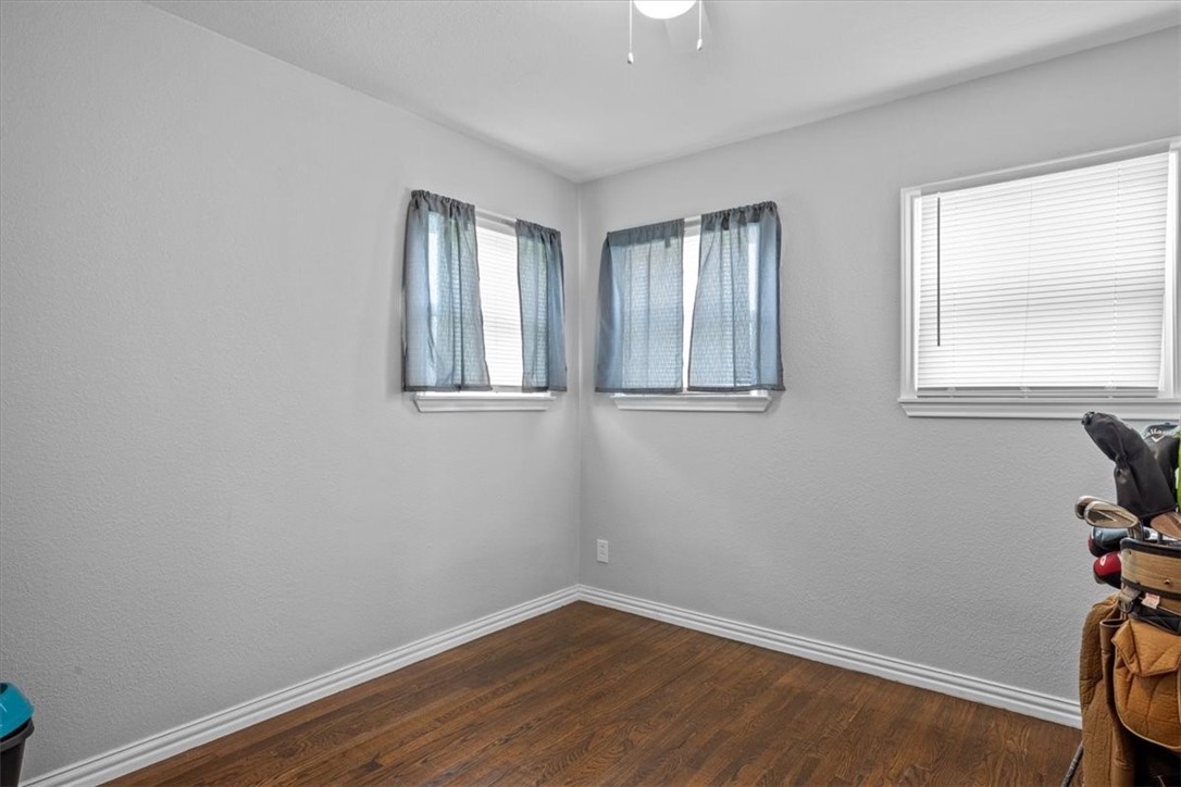 502 Bales Street Cleburne, TX 76033 - Photo 12 of 20 an empty room with wooden floor and windows