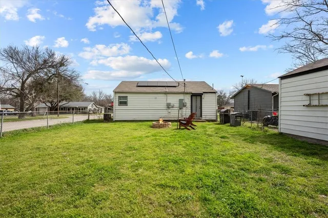 a yellow house sitting in middle of the grass