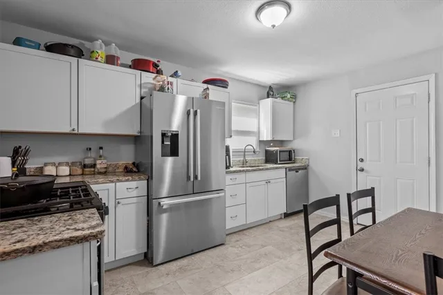 a kitchen with a refrigerator a stove and a cabinets
