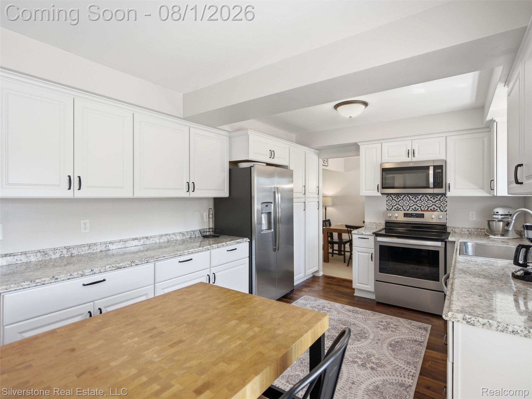 2135 Wayward Drive Rochester, MI 48309 - Photo 15 of 55 Kitchen featuring white cabinetry, light-toned countertops, stainless steel appliances, a patterned tile backsplash, and wood-finish flooring