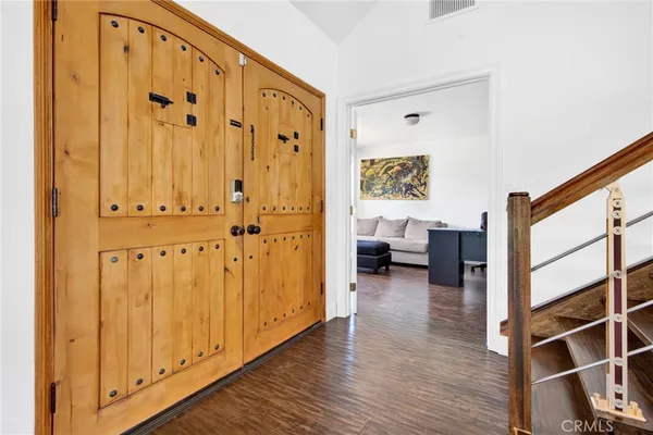 a view of a hallway with wooden floor and cabinet