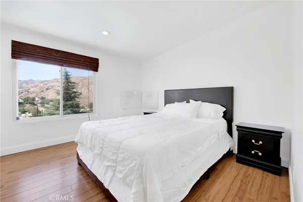 a large bed sitting in a bedroom next to a window