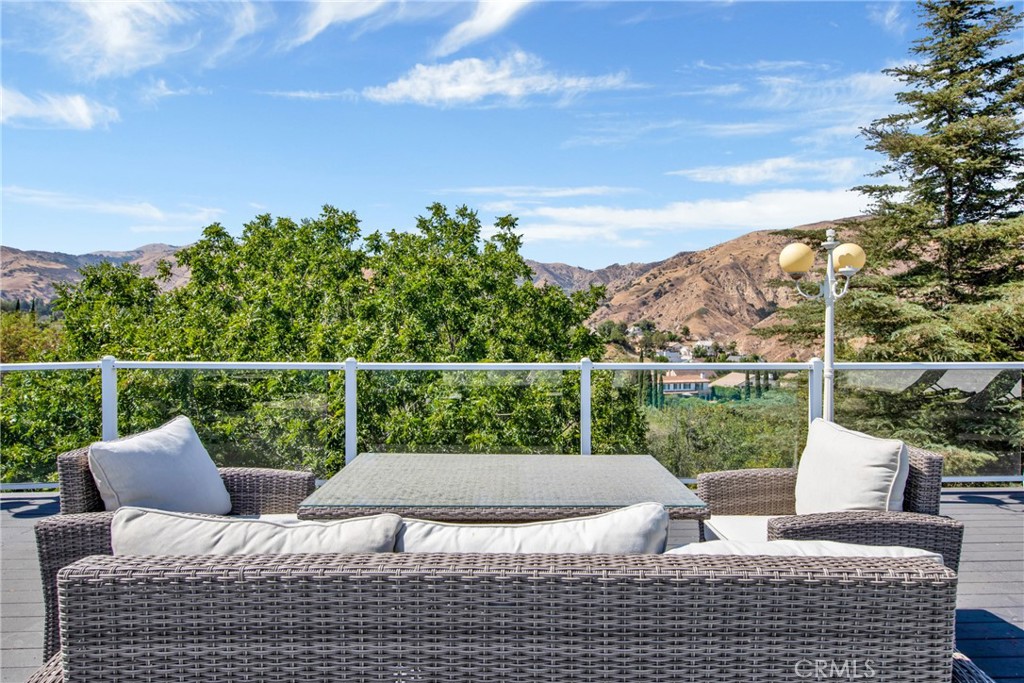 12036 Darby Avenue Porter Ranch, CA 91326 - Photo 2 of 37 a view of a patio with couches chairs and city view