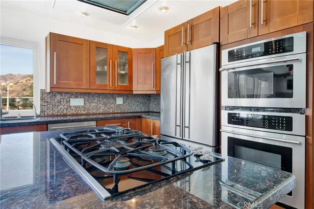 a kitchen with stainless steel appliances a stove sink and cabinets