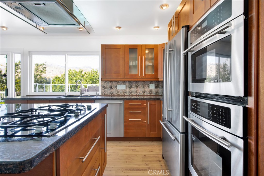 12036 Darby Avenue Porter Ranch, CA 91326 - Photo 22 of 37 a kitchen with stainless steel appliances a stove sink and cabinets