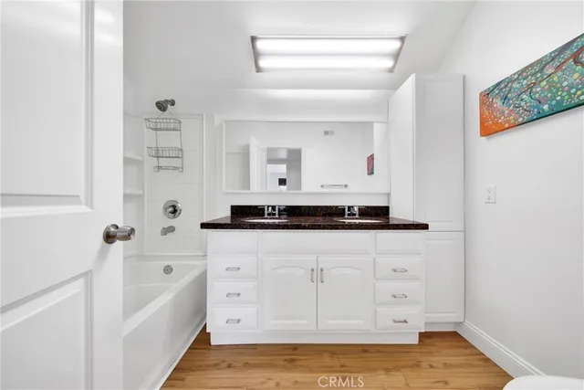 a bathroom with a granite countertop sink a mirror and a bathtub