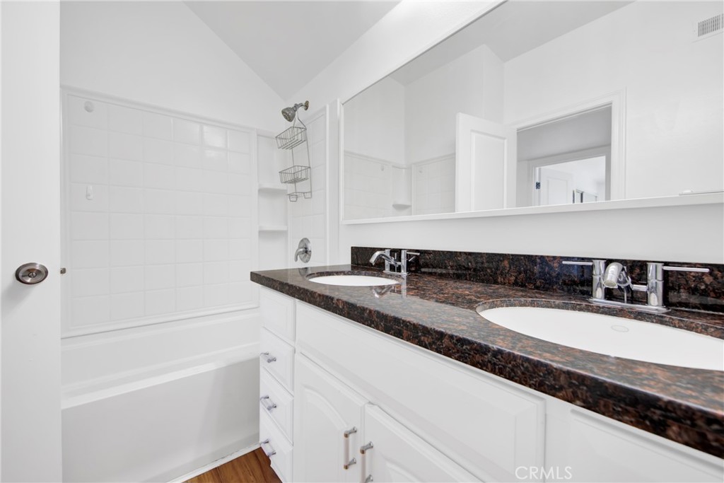 12036 Darby Avenue Porter Ranch, CA 91326 - Photo 29 of 37 a bathroom with a granite countertop sink a mirror and a bathtub