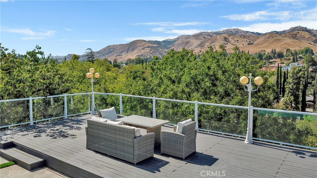 12036 Darby Avenue Porter Ranch, CA 91326 - Photo 5 of 37 a view of a roof deck with couches and wooden floor