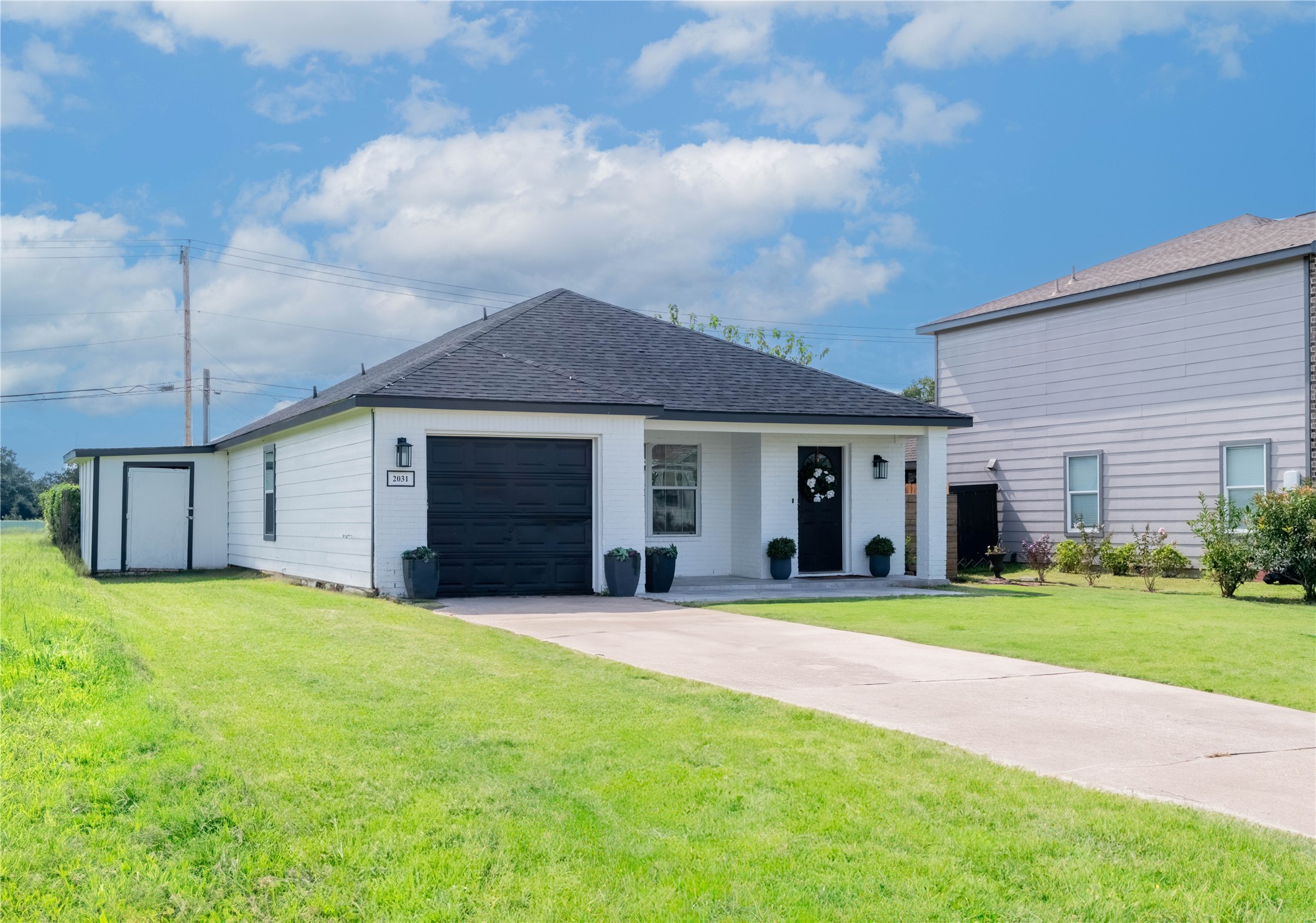 2031 7th Street Hempstead, TX 77445 - Photo 3 of 30 a front view of a house with a yard and garage