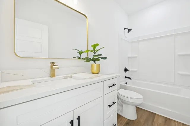 a bathroom with a sink a toilet and shower