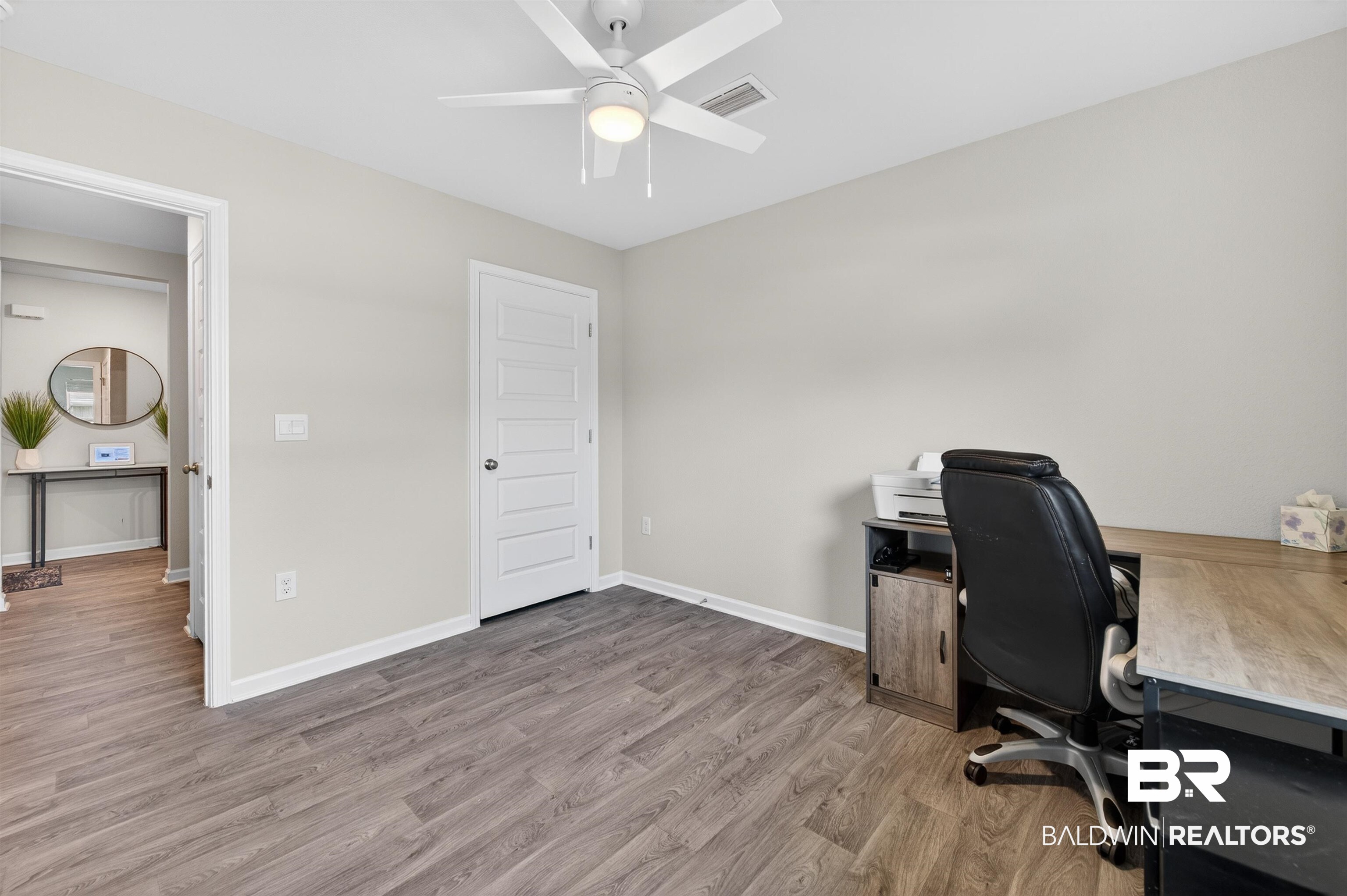 3213 Camino Real Loop Lillian, AL 36549 - Photo 59 of 61 Spacious room featuring wood-finish flooring, light gray walls, and a white ceiling fan with integrated lighting