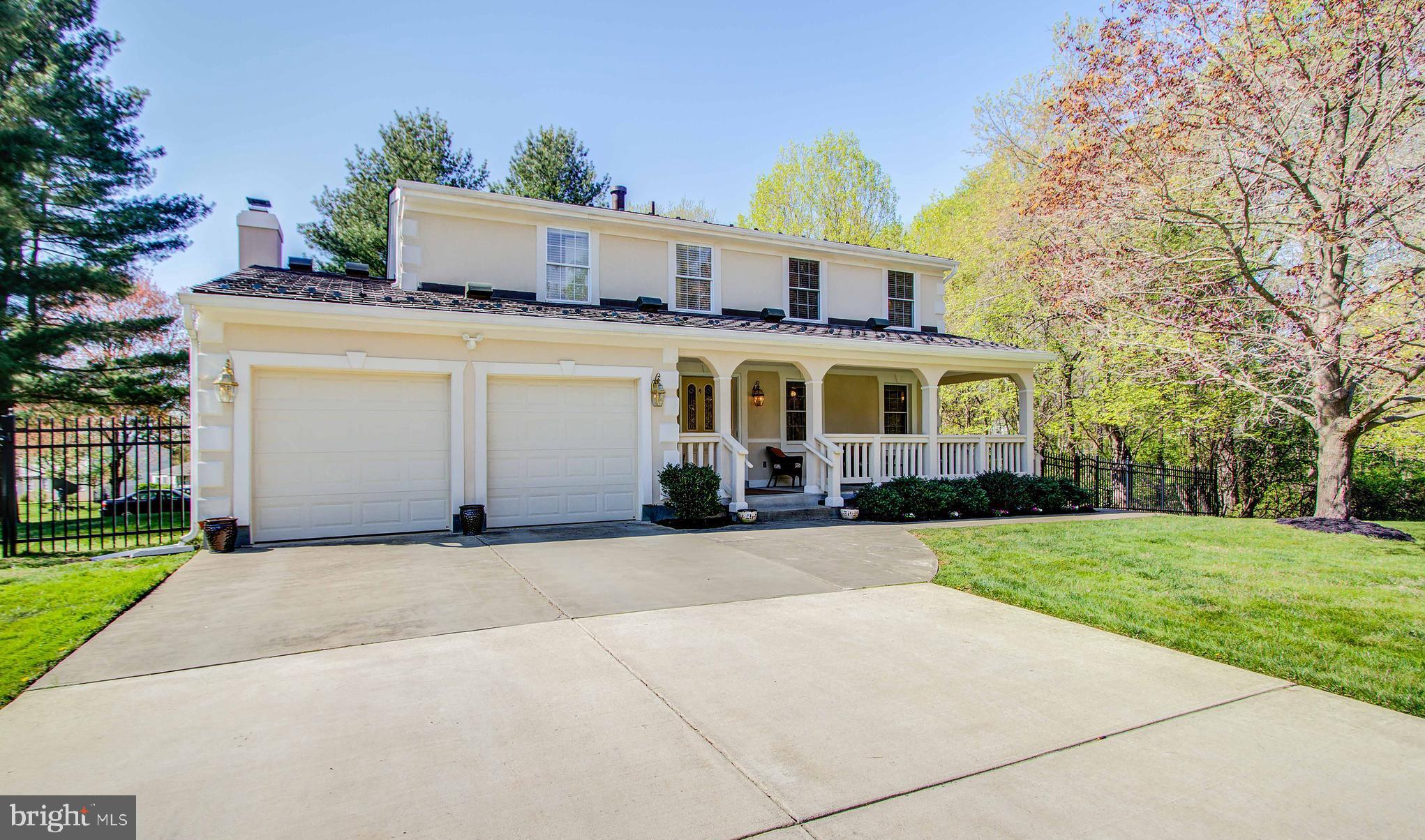 a view of a house with a yard and large tree