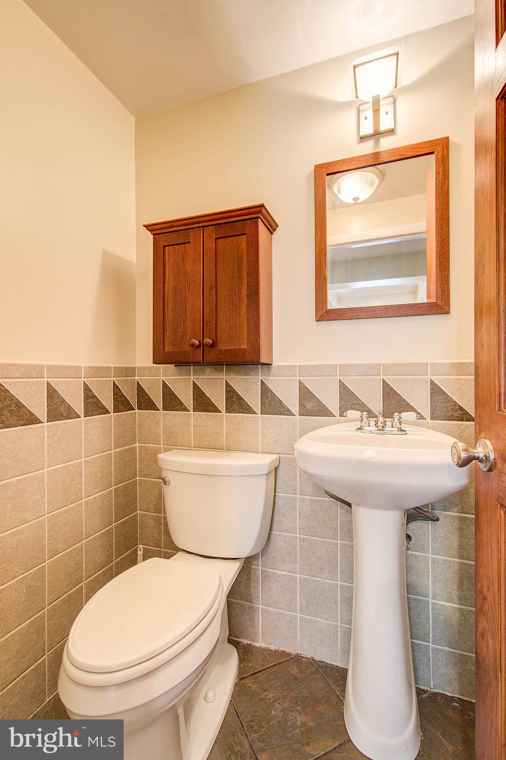 1413 Rainbow Drive Silver Spring, MD 20905 - Photo 22 of 50 a bathroom with a toilet a sink and mirror