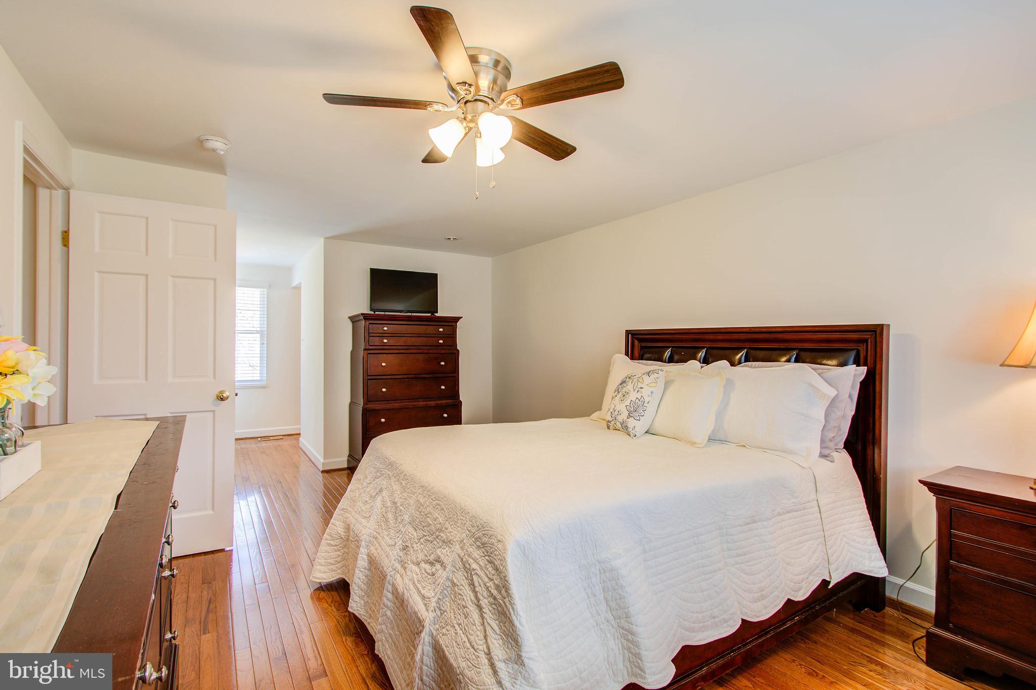 1413 Rainbow Drive Silver Spring, MD 20905 - Photo 27 of 50 a bedroom with a bed and wooden floor
