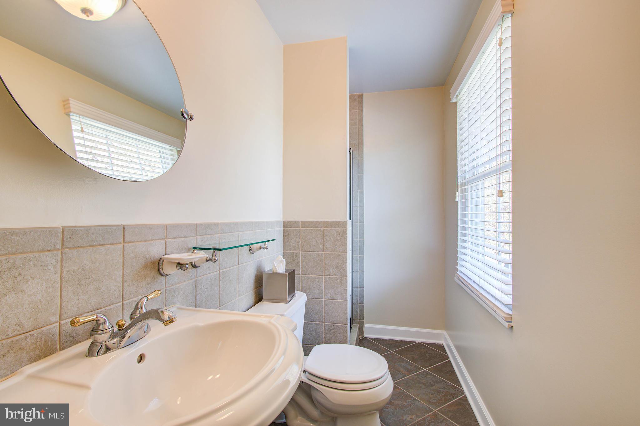 1413 Rainbow Drive Silver Spring, MD 20905 - Photo 30 of 50 a bathroom with a sink a toilet and a window