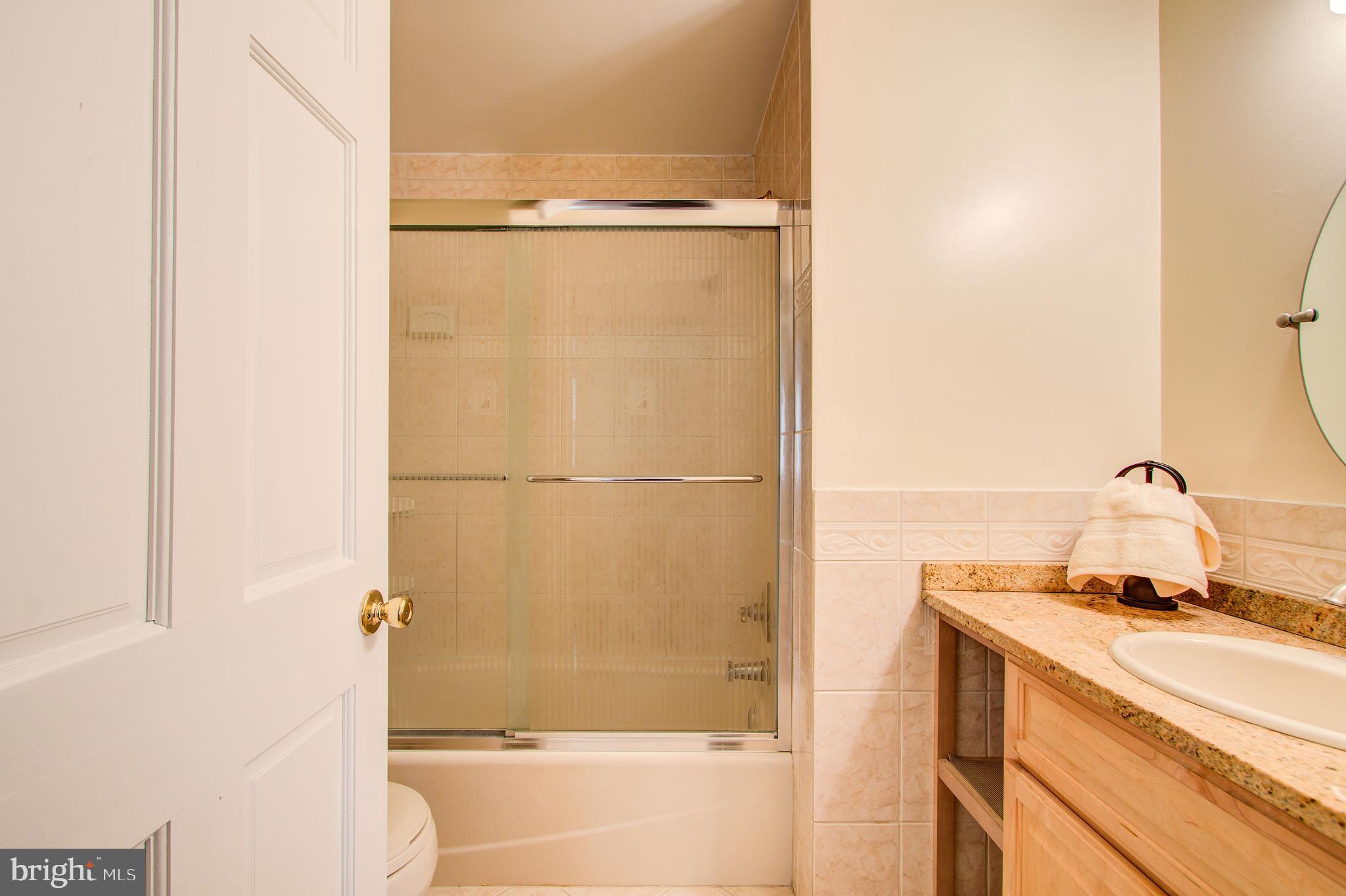 1413 Rainbow Drive Silver Spring, MD 20905 - Photo 33 of 50 a bathroom with a granite countertop sink mirror and a bathtub