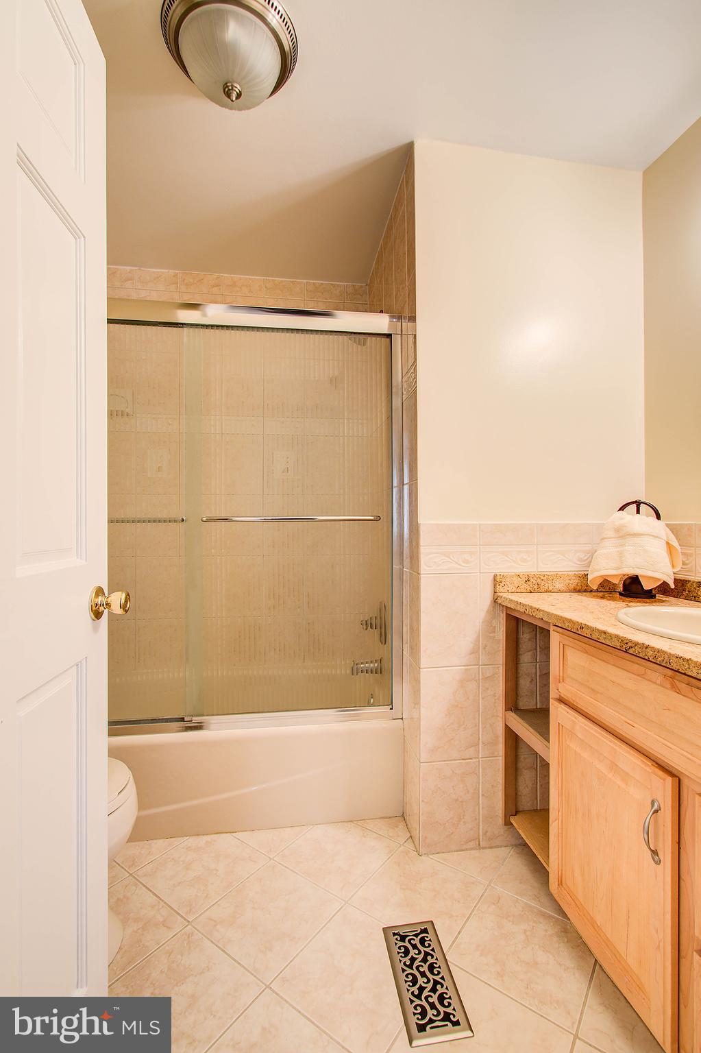 1413 Rainbow Drive Silver Spring, MD 20905 - Photo 34 of 50 a bathroom with a granite countertop sink a mirror and shower