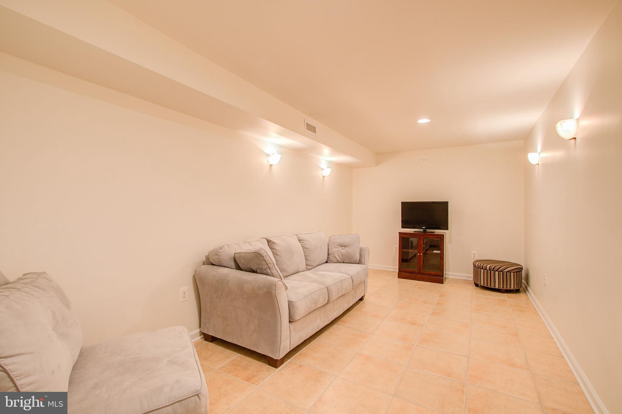 1413 Rainbow Drive Silver Spring, MD 20905 - Photo 39 of 50 a living room with furniture a flat screen tv and a couch