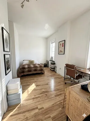 a bedroom with furniture and a wooden floor