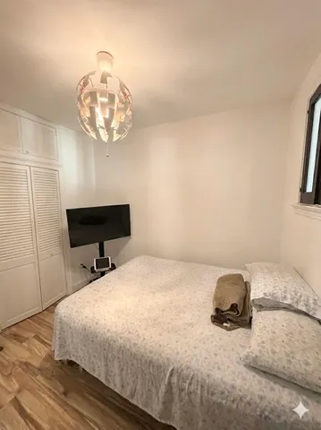 a bedroom with a bed and a chandelier