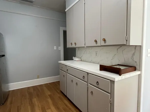 a kitchen with white cabinets and white appliances