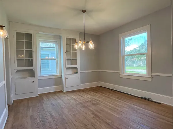 a view of a room with wooden floor and windows