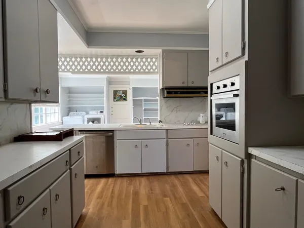 a kitchen with granite countertop stainless steel appliances a sink stove and cabinets