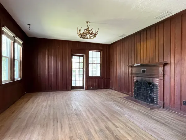 an empty room with windows closet and fireplace