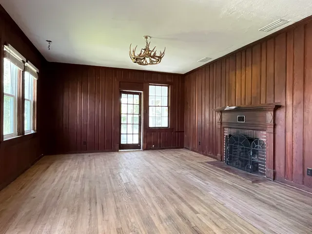 an empty room with windows closet and fireplace