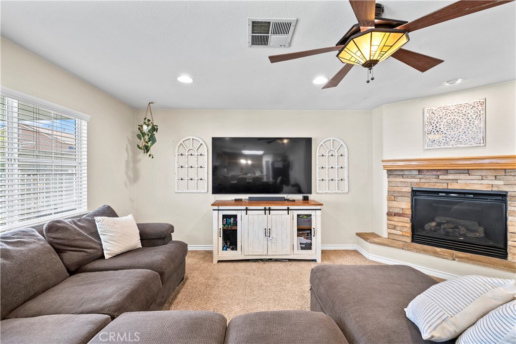 7219 Birch Tree Place Fontana, CA 92336 - Photo 13 of 49 a living room with furniture a flat screen tv and a fireplace