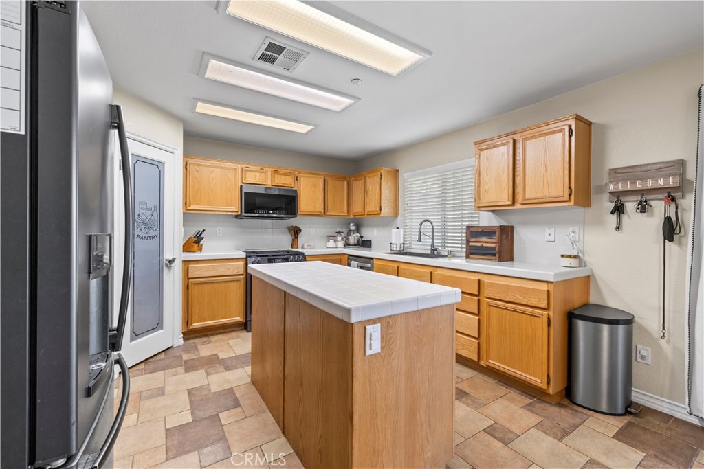 7219 Birch Tree Place Fontana, CA 92336 - Photo 18 of 49 a kitchen with stainless steel appliances granite countertop a stove top oven a sink a counter top space and cabinets