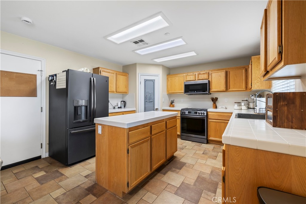 7219 Birch Tree Place Fontana, CA 92336 - Photo 19 of 49 a kitchen with stainless steel appliances granite countertop a refrigerator stove and sink